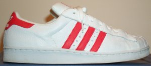 adidas Superstar low-top basketball shoe: white leather, red trim and stripes