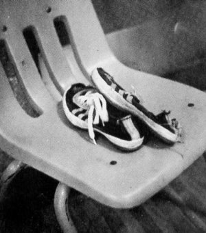 Well-worn pair of Converse Track Training Shoes in a plastic chair Well-worn pair of Converse Track Training Shoes in a plastic chair
