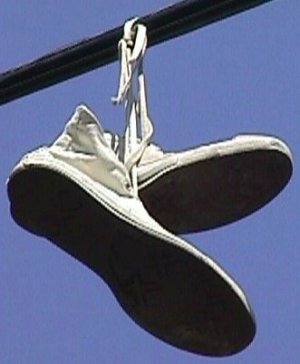 High-top sneakers hanging from a utility line High-top sneakers hanging from a utility line